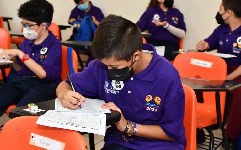 Students in classroom setting, focused on exam papers